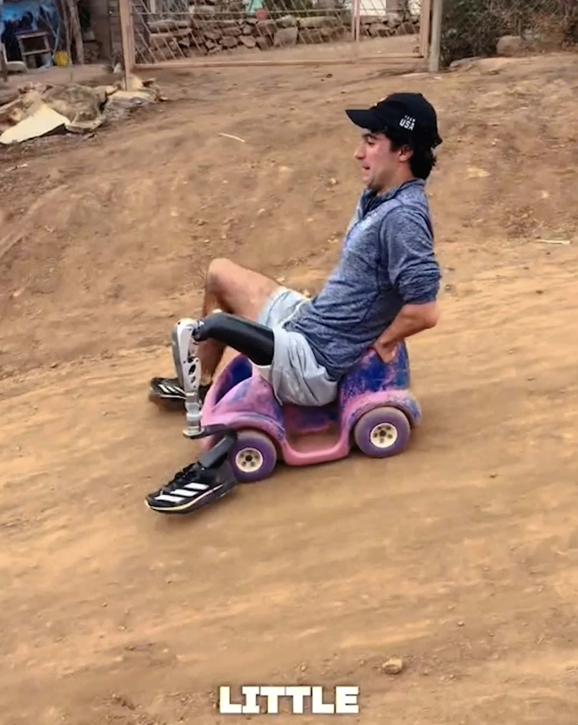 Ezra fährt mit einem Kinderauto einen Abhang hinunter