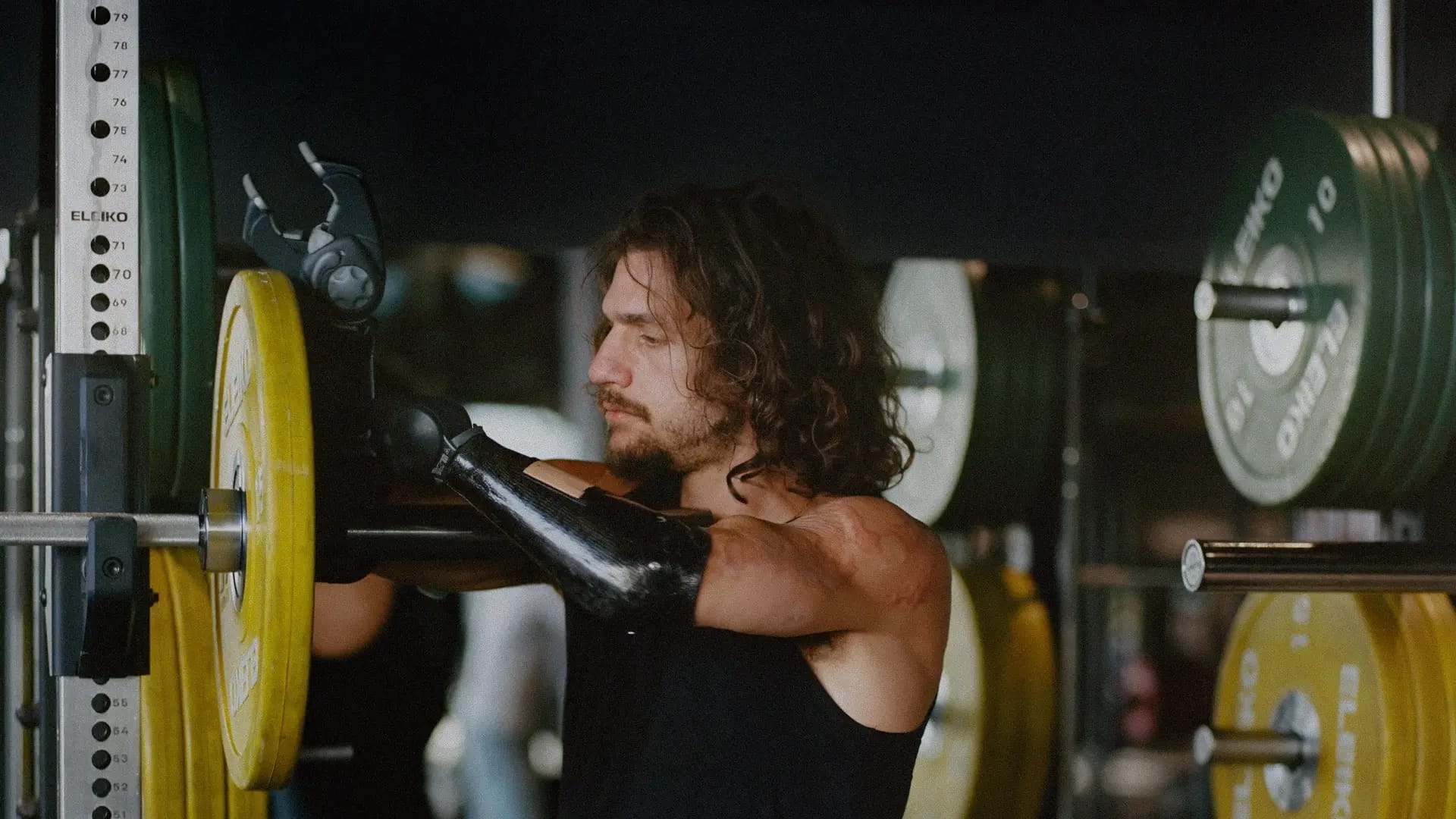 Davide putting weights on a barbell with his prosthetic arm