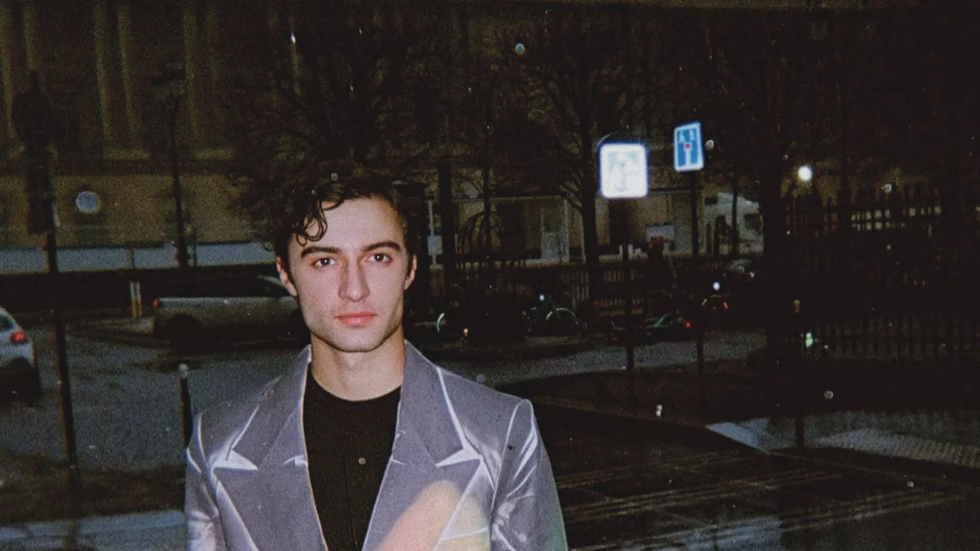 Ezra smiling at the camera dressed in a suit