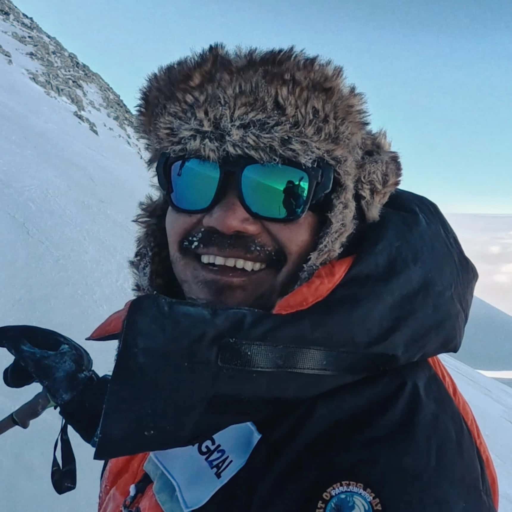 Hari smiling at the camera on a mountain